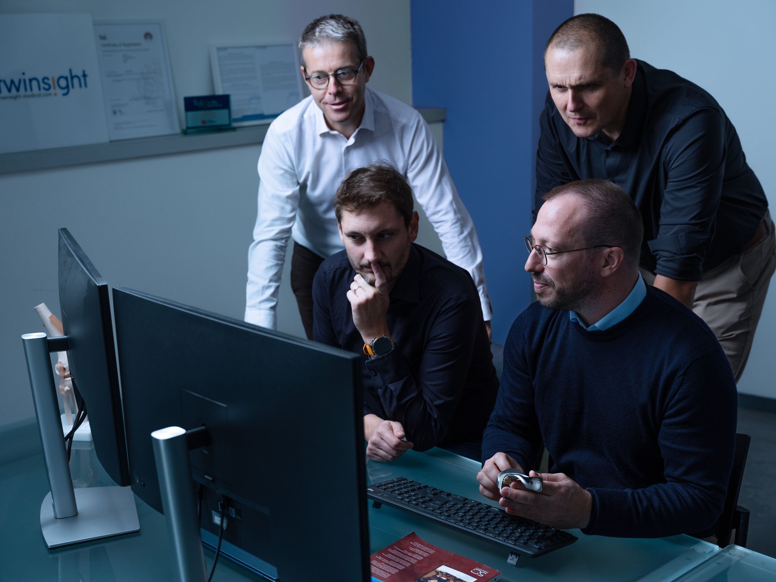 The team discussing a case around a workstation